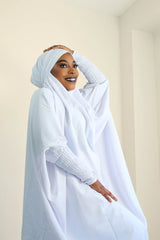 a womn is wearing white set jilbab