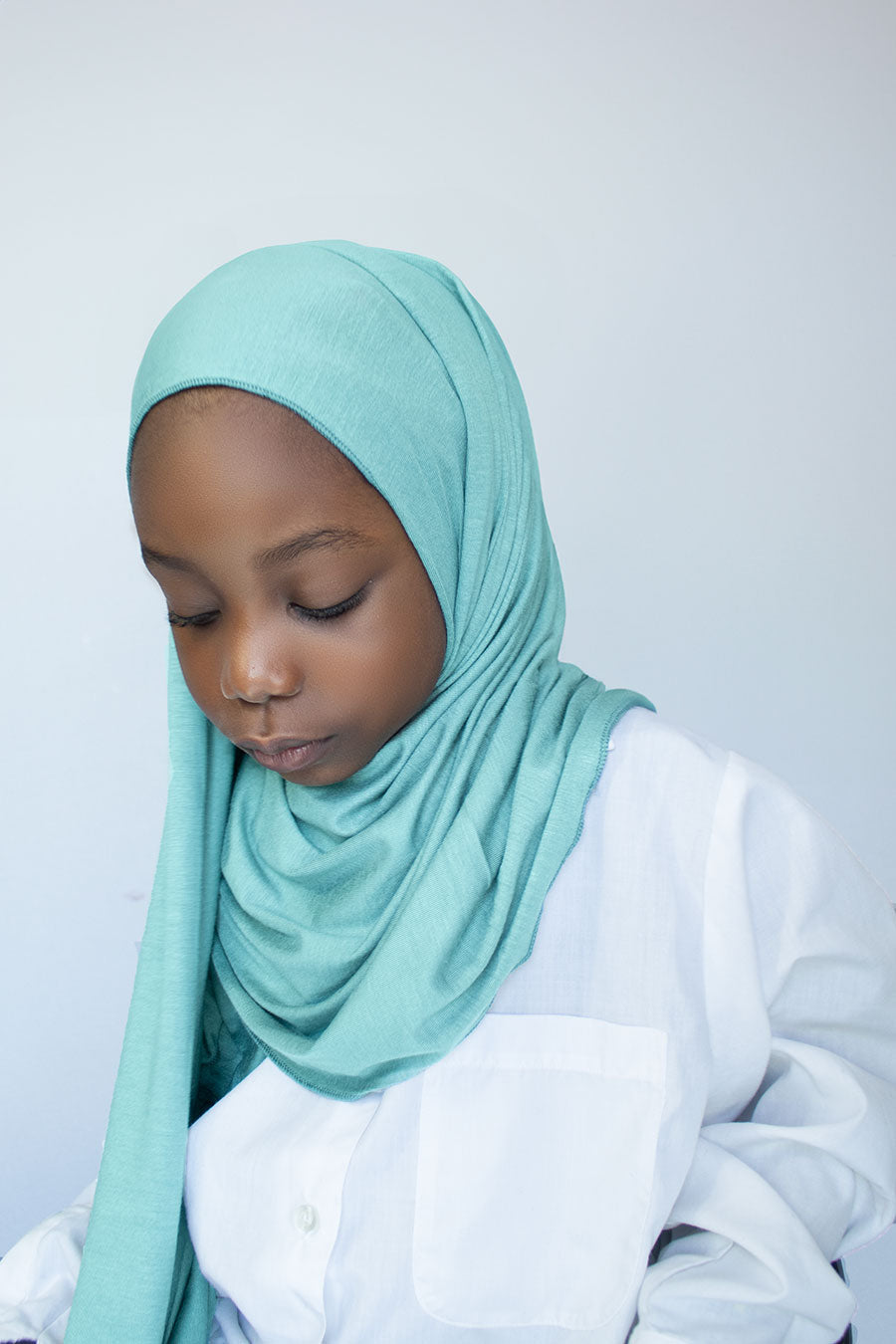 little girl is wearing blue jersey hijab